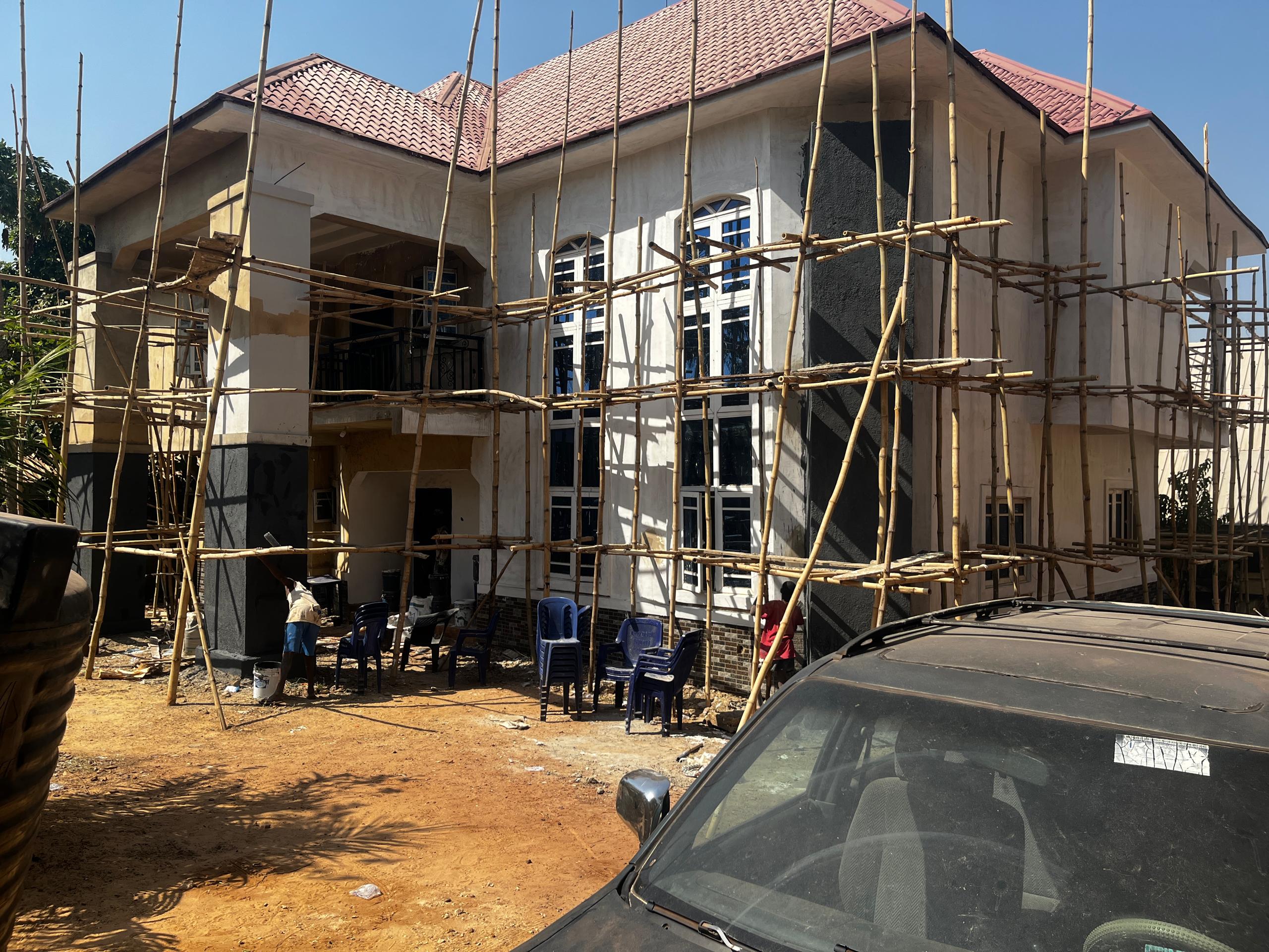 Oakacers site team raising a duplex behind bamboo scaffolding